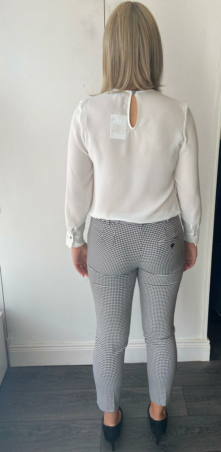 Cream shirt with black bow detail.