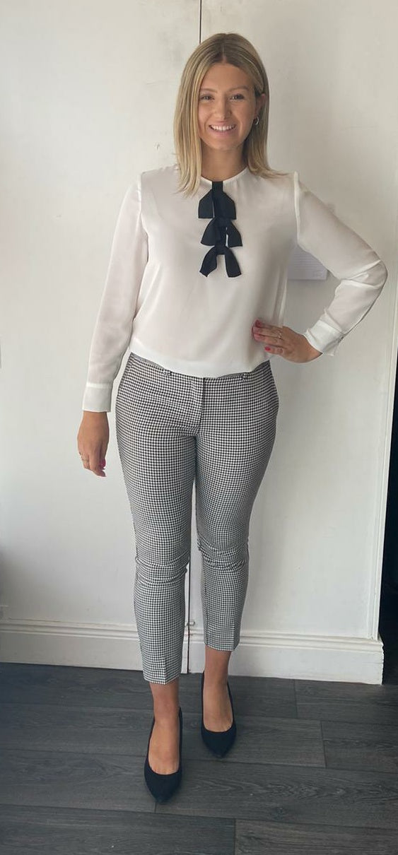 Cream shirt with black bow detail.