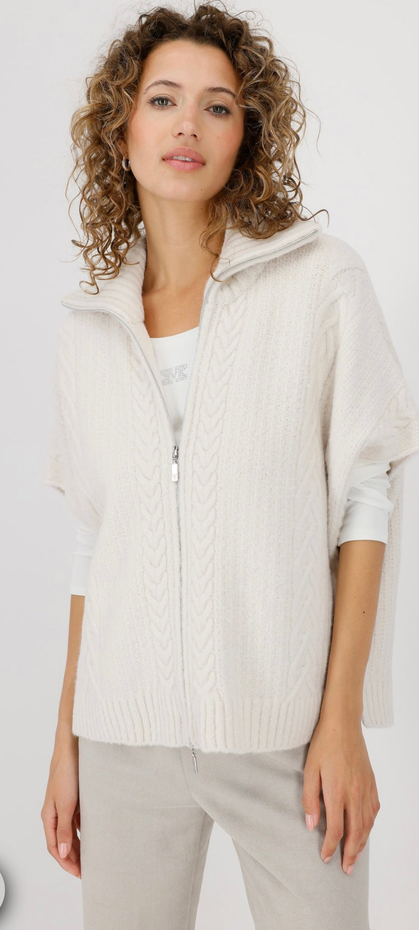 KNITTED CAPE WITH CABLE PATTERN
COLOR: Oat milk