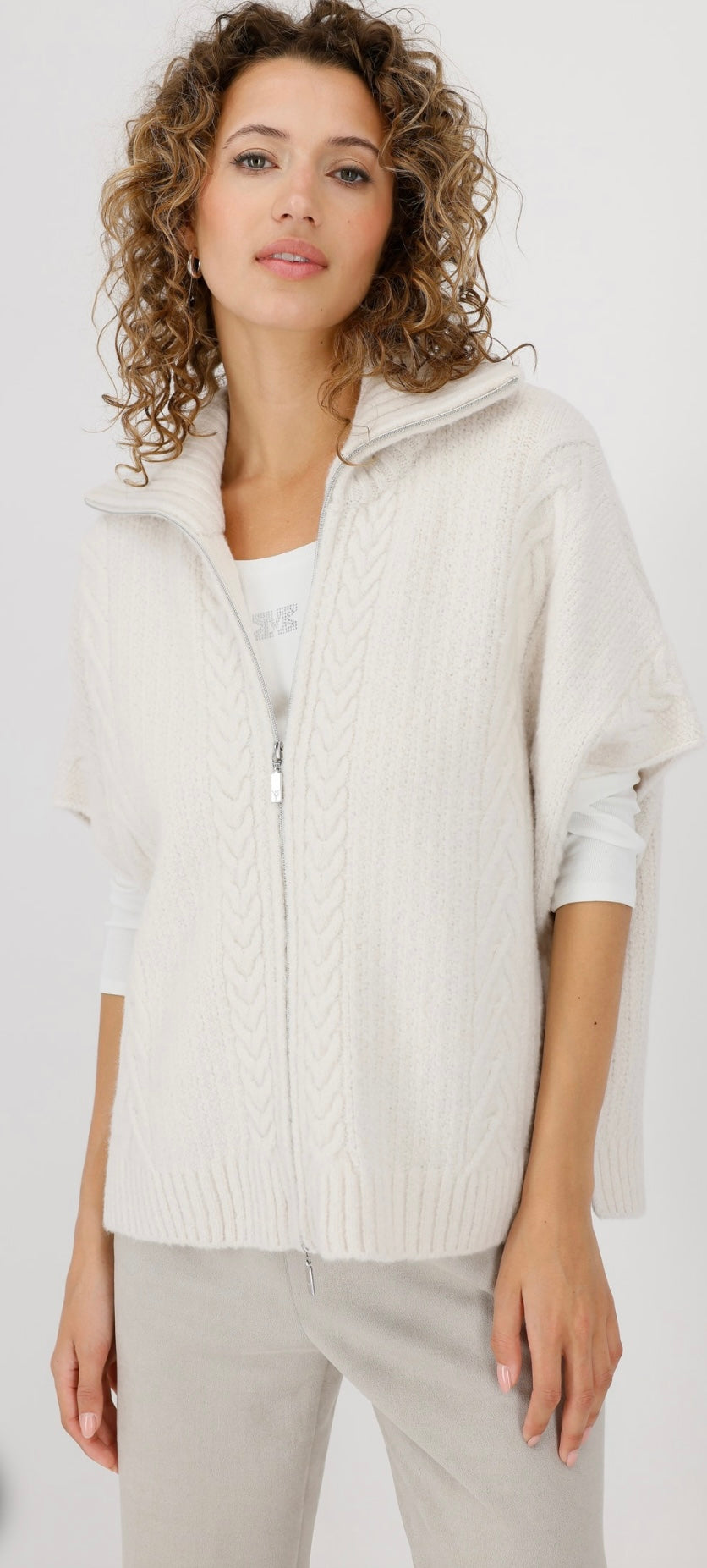 KNITTED CAPE WITH CABLE PATTERN
COLOR: Oat milk