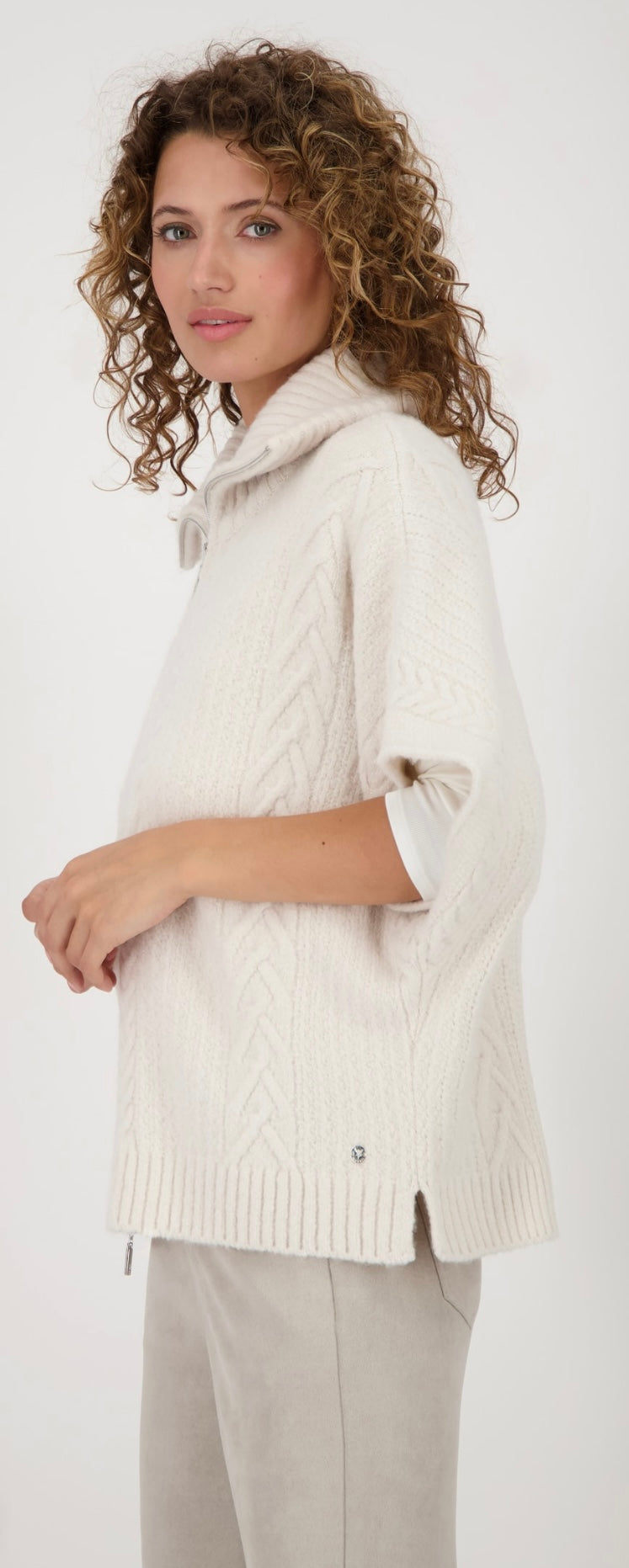 KNITTED CAPE WITH CABLE PATTERN
COLOR: Oat milk