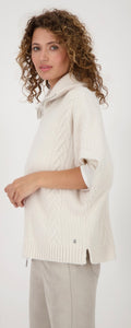 KNITTED CAPE WITH CABLE PATTERN
COLOR: Oat milk